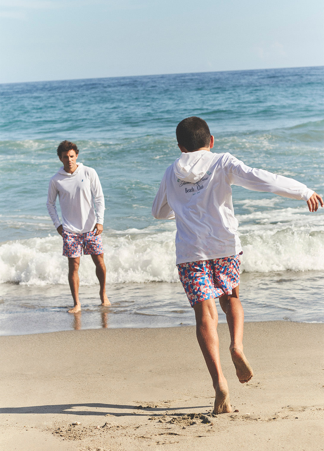 Two people on a beach with ocean waves in the background