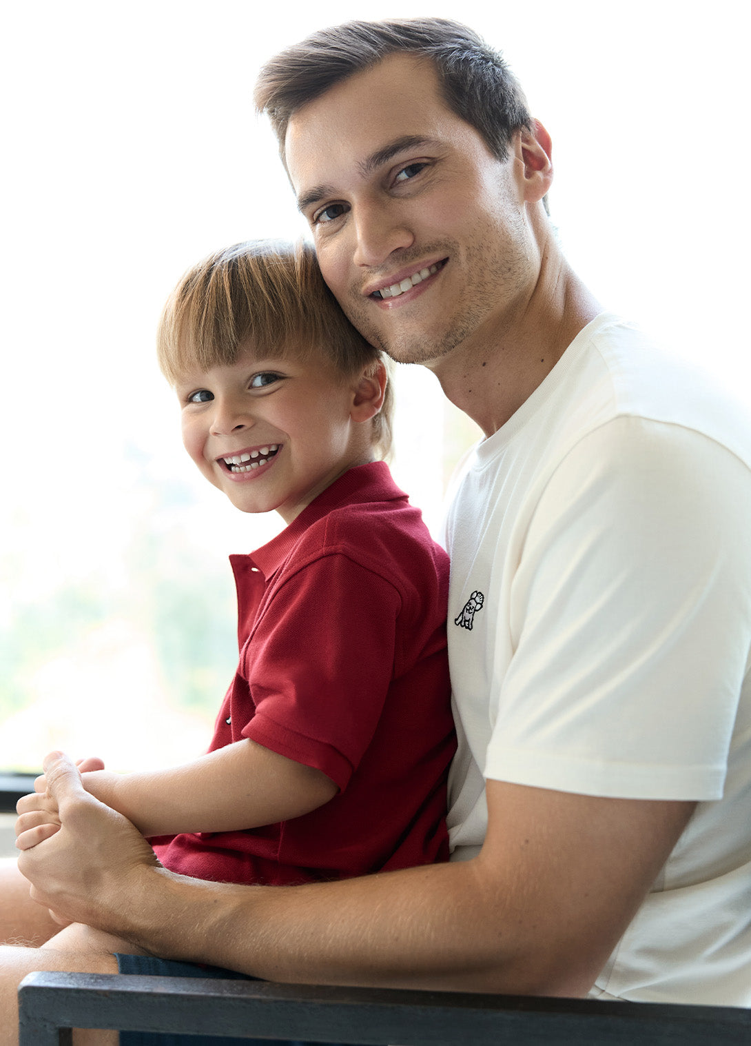 Man and child sitting together, smiling at the camera