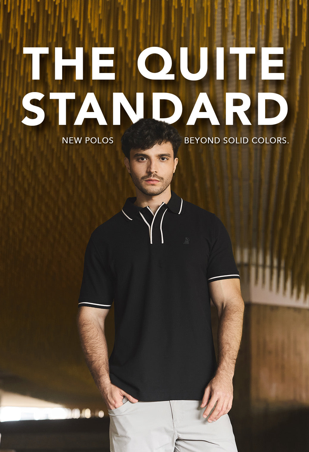 Men wearing a black polo and light beige pants on a yellow background