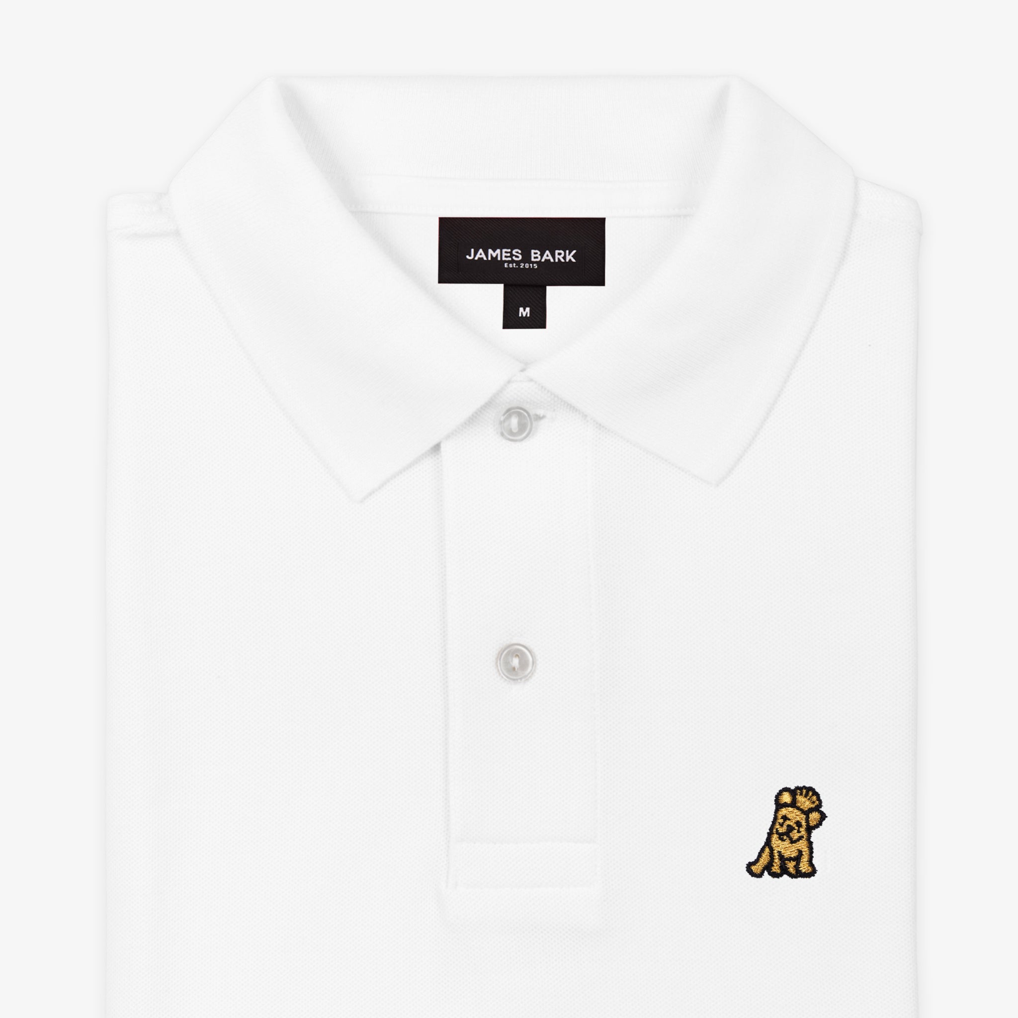 Close-up of the collar and upper part of the white polo shirt, showing the buttons and the small golden embroidered logo on the chest.