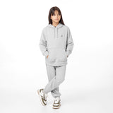 Full-body view of a child wearing a gray hoodie with a small embroidered dog logo, paired with matching jogger pants and sneakers, standing casually.