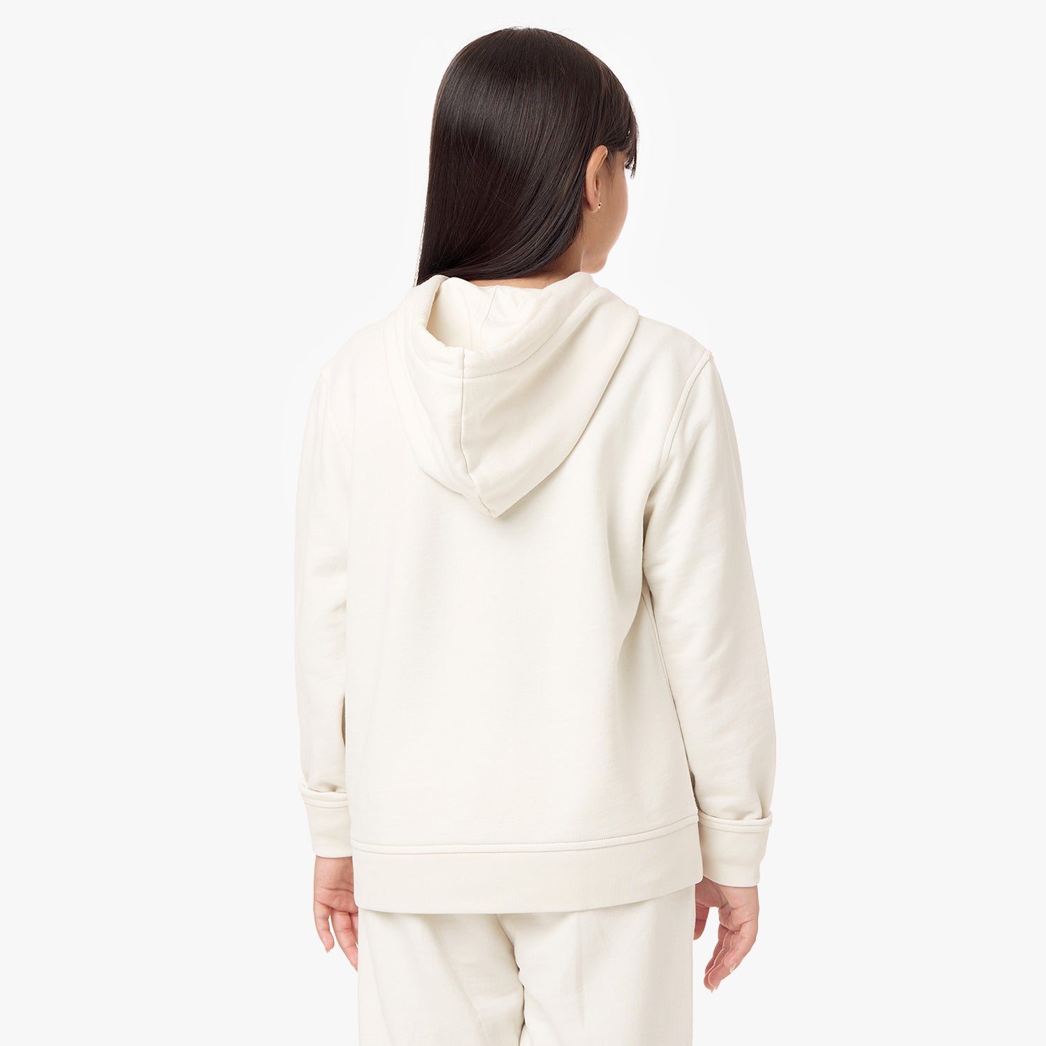 Back view of a child wearing the cream-colored hoodie, showcasing the hood and minimalist design.