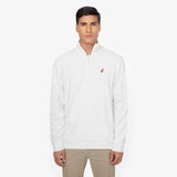 Man wearing a white half-zip sweatshirt with a small embroidered dog logo on the left chest. The sweatshirt has a minimalist design and is paired with beige pants. White background with the model displaying a neutral expression