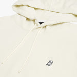 Close-up of the embroidered dog logo on the chest of the cream-colored hoodie, highlighting the fine details