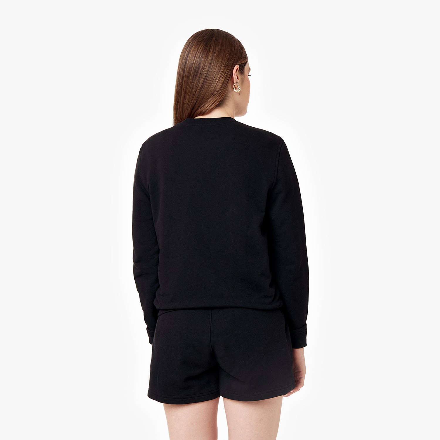 Back view of the black crewneck sweatshirt worn by a woman