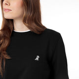 Close-up side profile of the woman wearing the black crewneck sweatshirt, showing the neckline detail