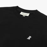 Close-up of the embroidered logo on the black crewneck sweatshirt.