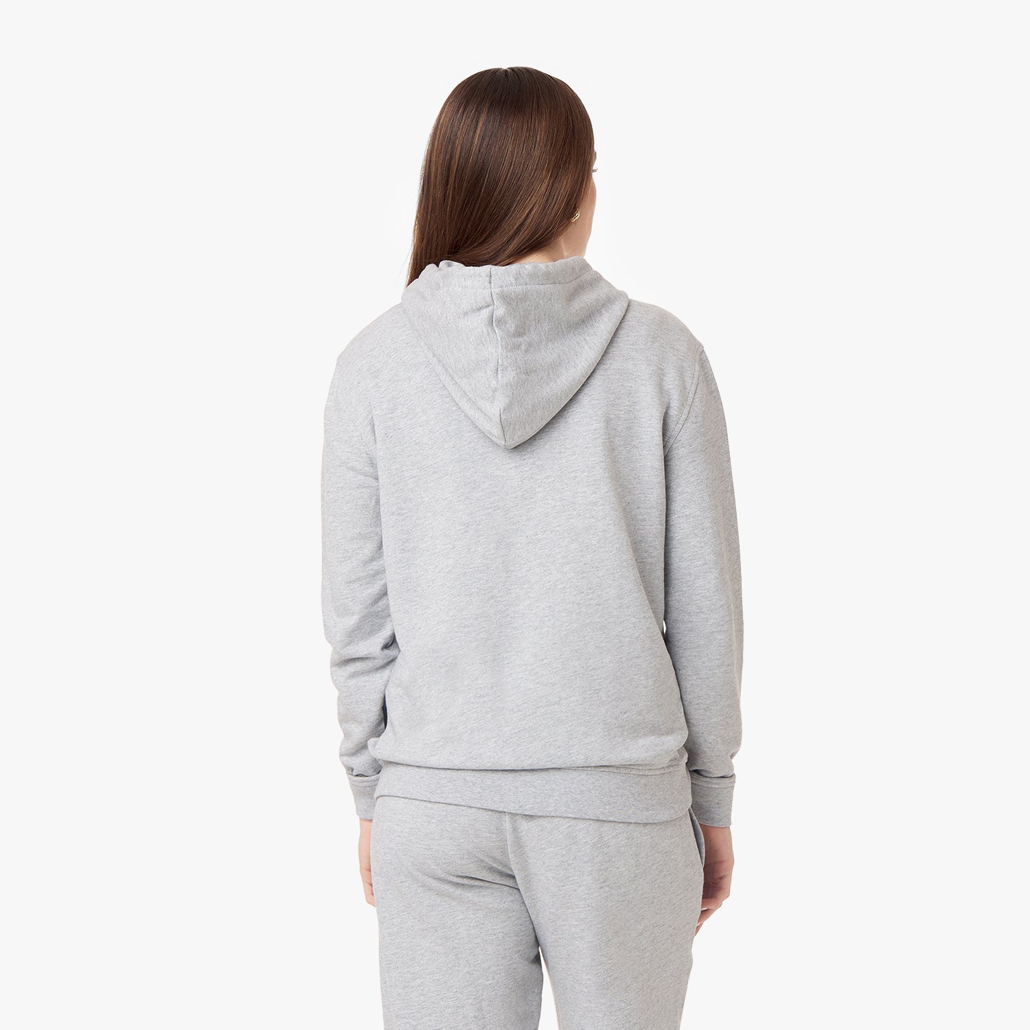 Back view of a person wearing a light gray hoodie and matching sweatpants, with long straight brown hair, against a plain white background