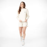 Woman modeling an off-white sweatshirt and matching shorts set, paired with white sneakers and striped socks. The outfit features embroidered French Bulldog logos for a stylish and casual look.