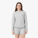 Woman wearing a light gray sweatshirt and matching shorts set, both featuring an embroidered French Bulldog logo, styled for a comfortable and casual look.