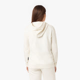 Back view of a woman wearing a cream-colored hoodie with matching sweatpants, showcasing the simple design and relaxed fit of the hoodie.