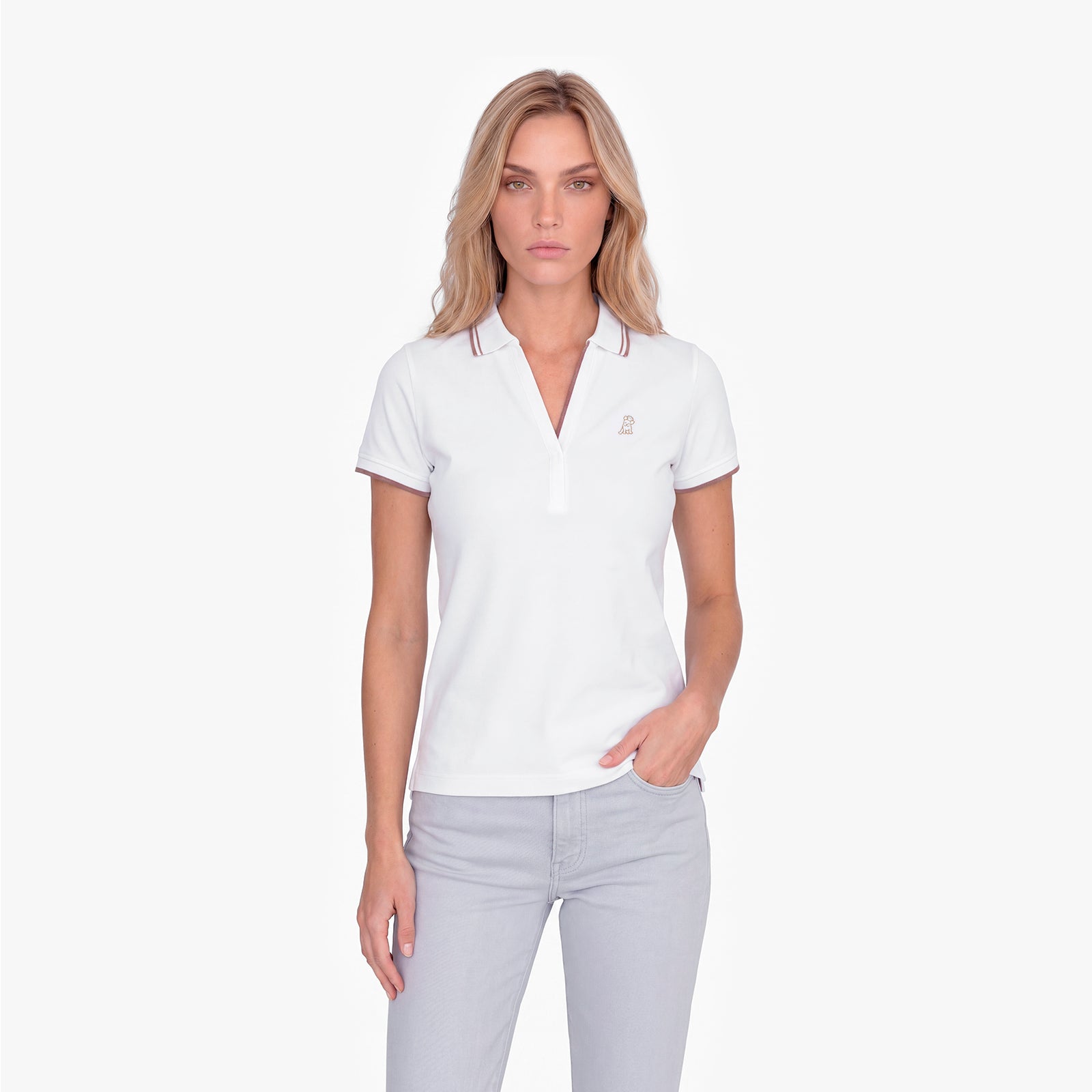 Woman wearing a white polo with an embroidered dog logo on a white background