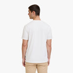 A man viewed from the back wearing a plain white short-sleeve T-shirt and khaki pants