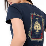 A close-up of a model wearing a navy blue T-shirt, showing the back graphic. The graphic is styled like a playing card deck with gold and red details, featuring the text 'JAMES BARK EST'.
