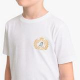 A child wearing a white short-sleeve T-shirt with a gold and navy blue emblem printed on the left chest.