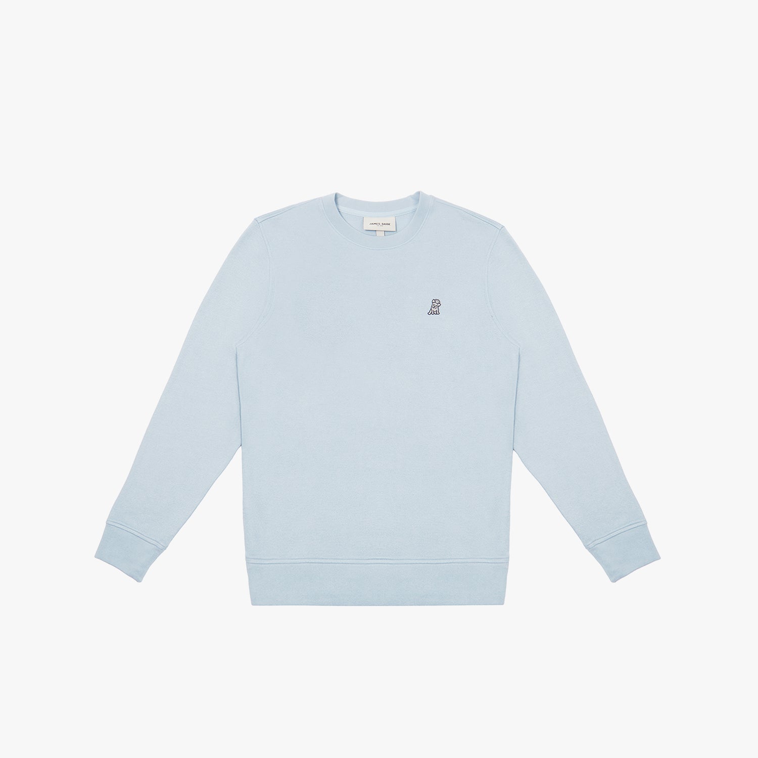 A light pastel blue crewneck sweatshirt laid flat on a white background. It features long sleeves, ribbed cuffs, and a ribbed hem. A small embroidered logo of a dog in dark thread is positioned on the left chest area. The neckline includes a white label with black text displaying the brand "JAMES BARK." The fabric appears soft and comfortable.