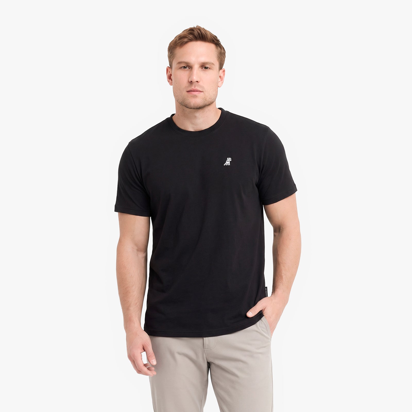 A man wearing a black short-sleeve crewneck t-shirt with a small white embroidered logo.