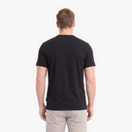A man viewed from behind wearing a black short-sleeve crewneck t-shirt.