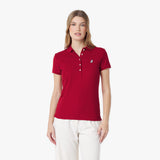 Woman wearing a red polo shirt with a logo on a white background