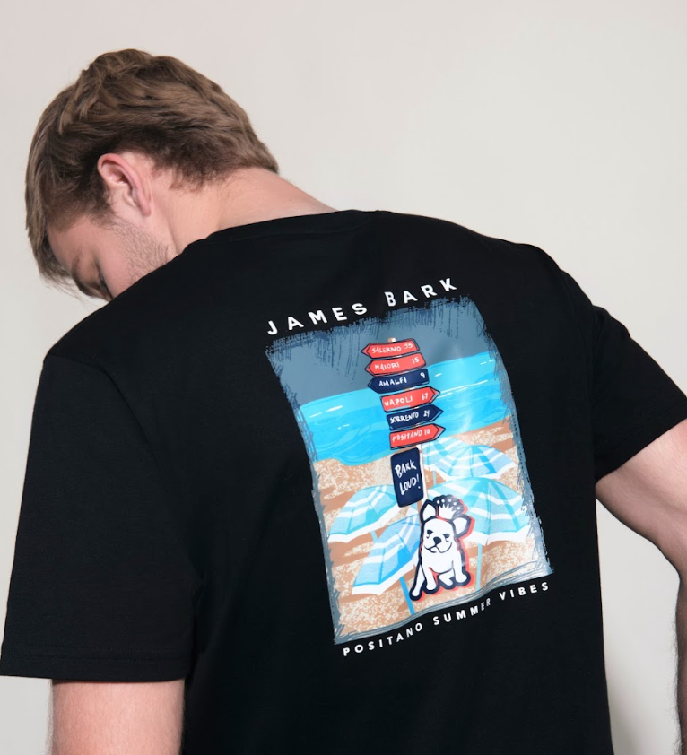Person wearing a black t-shirt with a colorful graphic on the back, standing against a plain background.