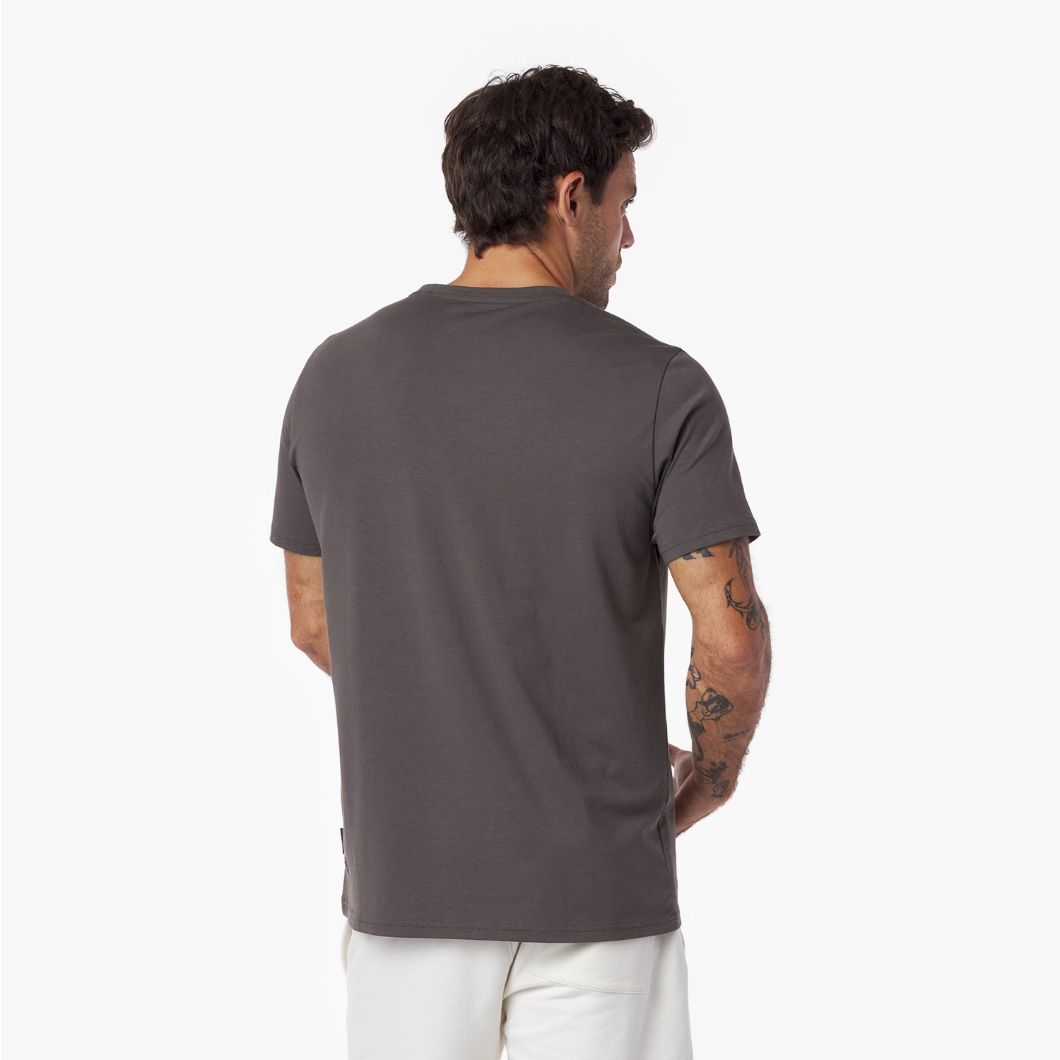 Back view of a man wearing a gray t-shirt on a white background