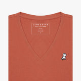 Front view of a terracotta-colored women's V-neck t-shirt laid flat against a white background, showing the short sleeves and the black and white embroidered logo on the left chest