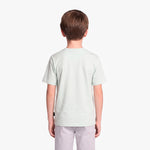 A child viewed from the back wearing a light green T-shirt and light gray pants