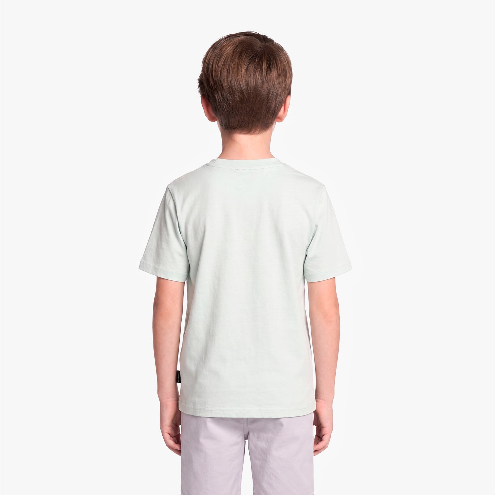 A child viewed from the back wearing a light green T-shirt and light gray pants