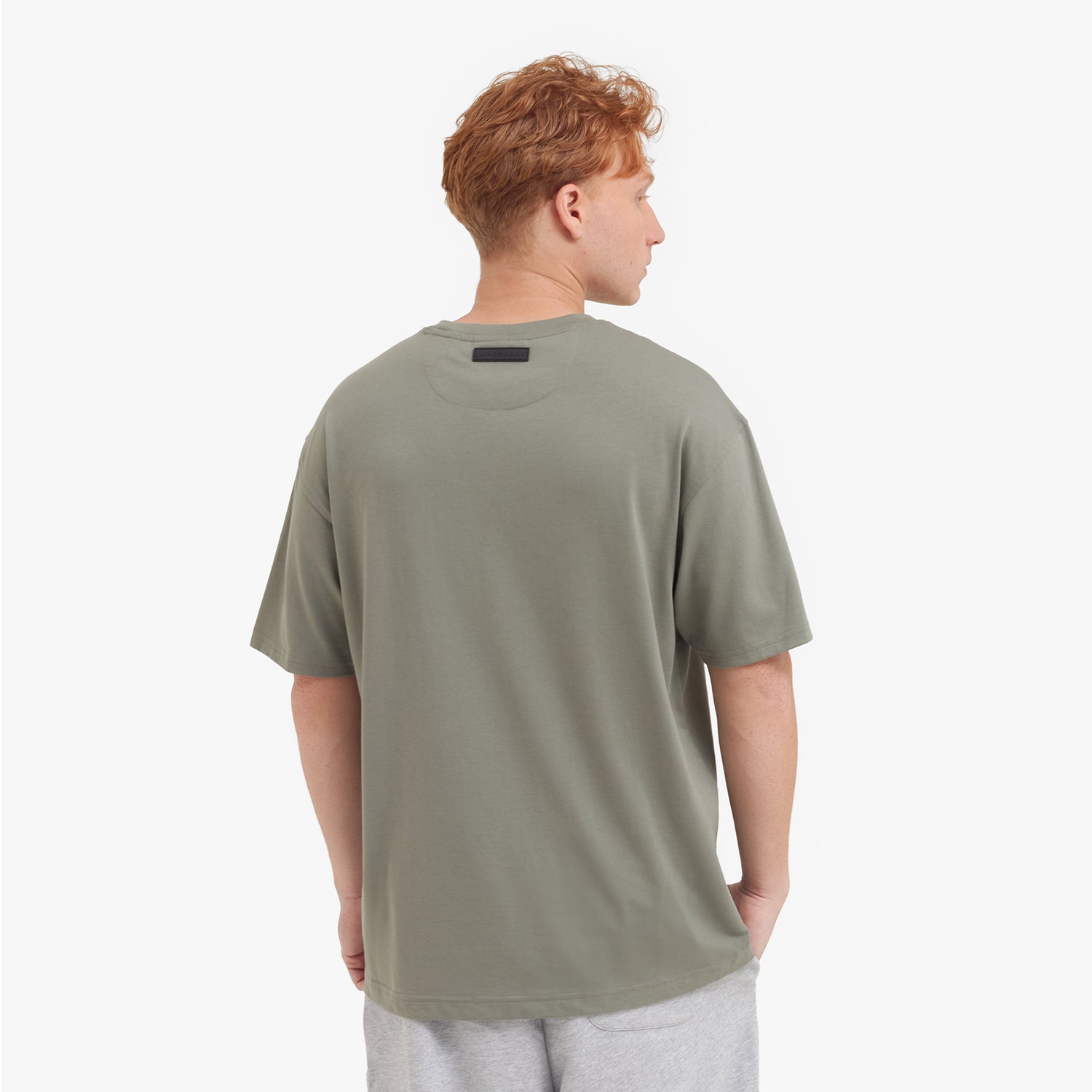 Back view of a man wearing a green t-shirt on a white background