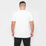 A rear view of a man wearing the white T-shirt and black pants.