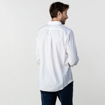 Back view of a man wearing the white button-up shirt: The man is standing with his back to the camera, showing the back fit and length of the shirt.