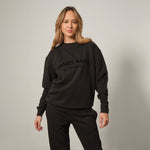 Model wearing a black sweatshirt with 'James Bark Elements' text on the chest